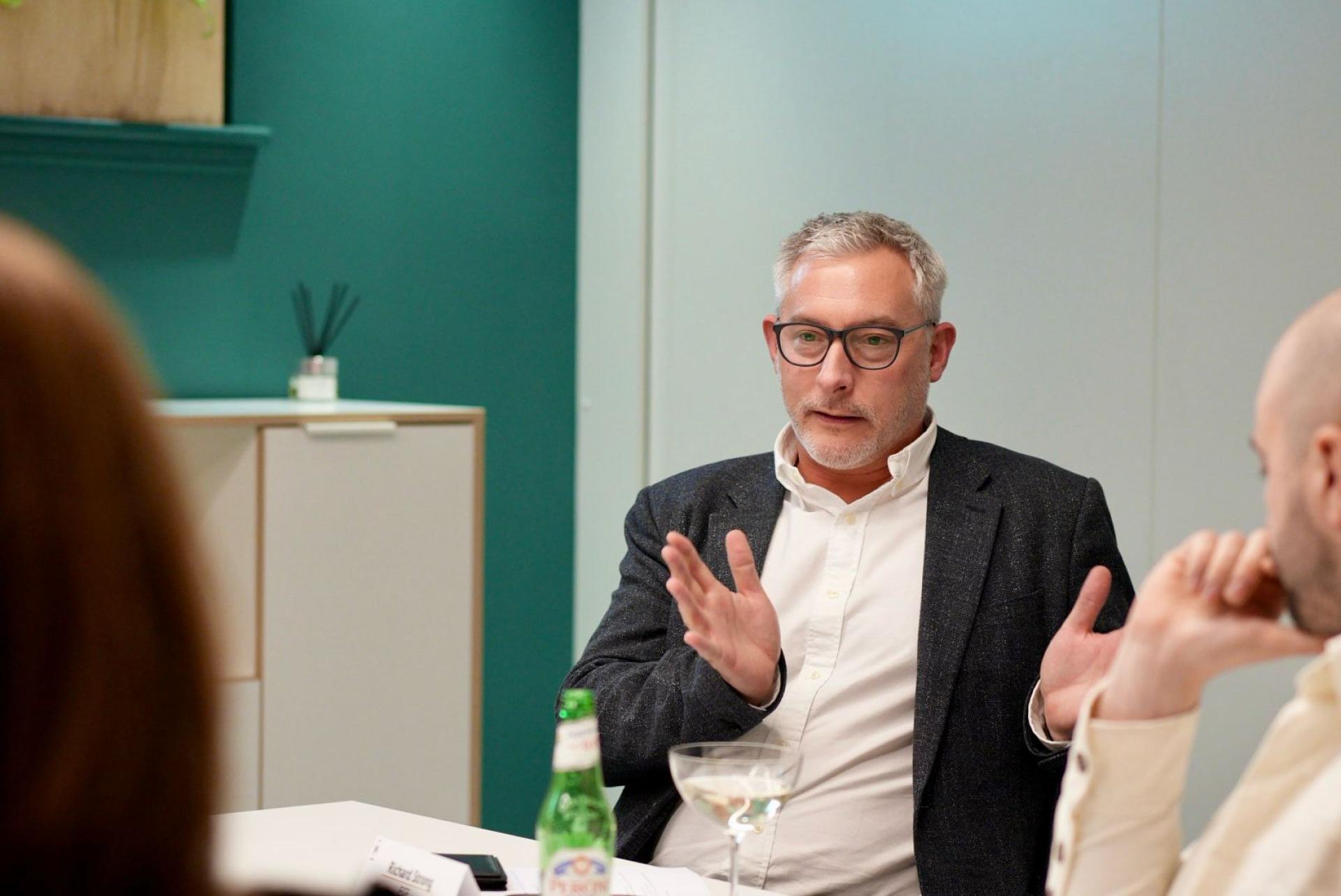 Business leaders discussing workplace flexibility trends during a meeting, with a focus on collaboration and innovation.