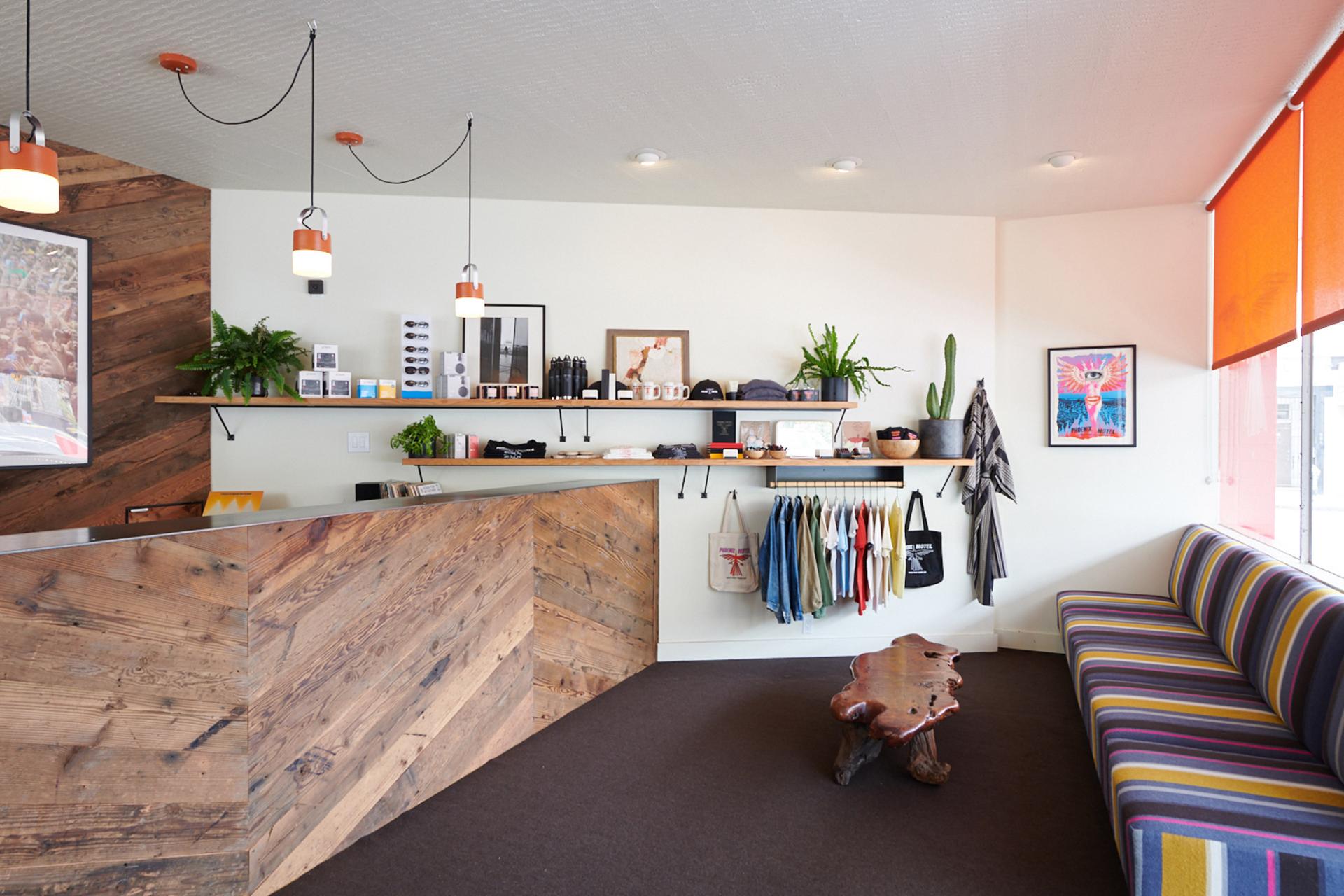 Modern hotel reception area at the Phoenix Hotel, featuring rustic wooden decor, shelves with merchandise, and colorful seating.