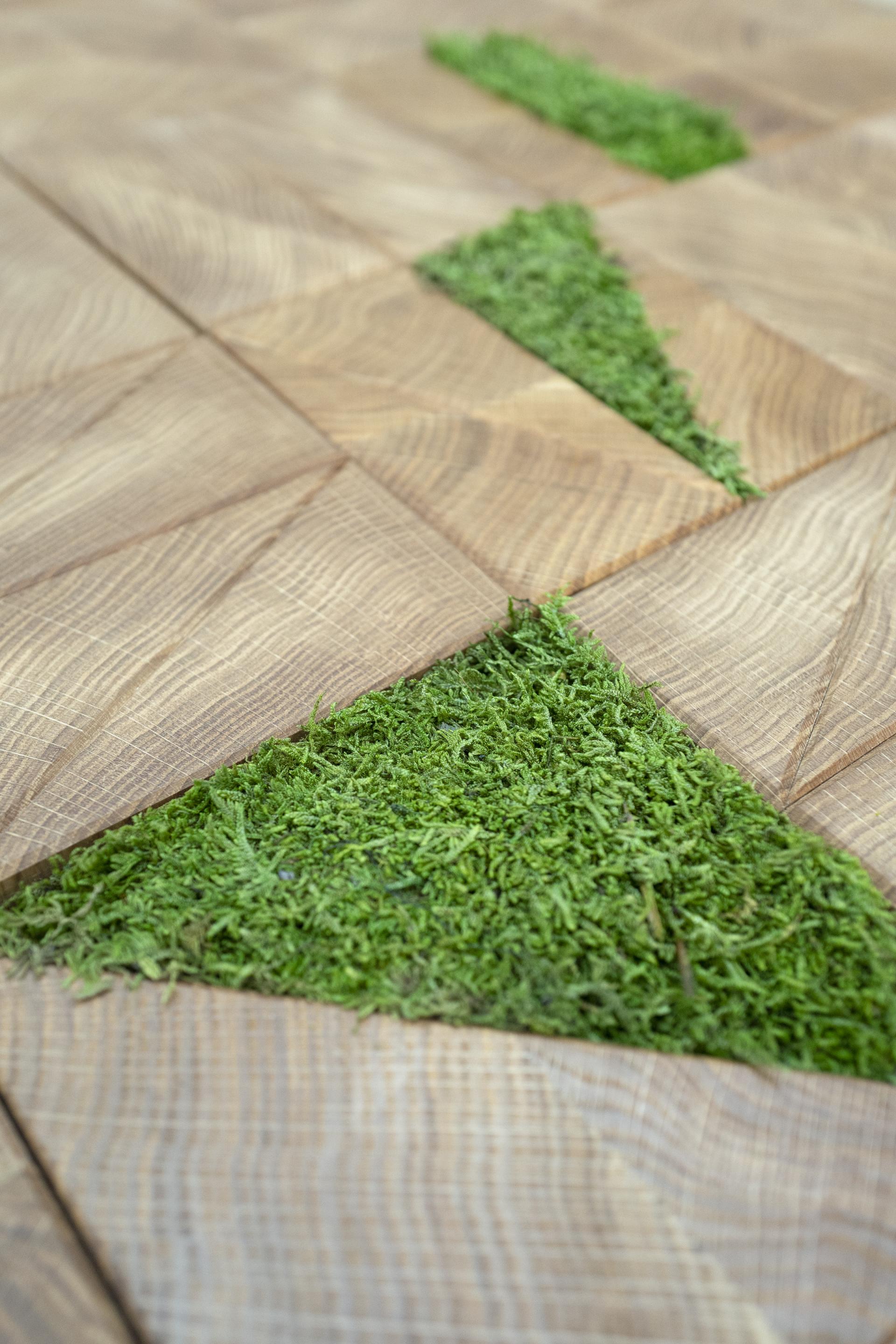 Sustainable wooden flooring featuring geometric patterns with embedded green moss, highlighting Innerspace Cheshire's authentic design approach.