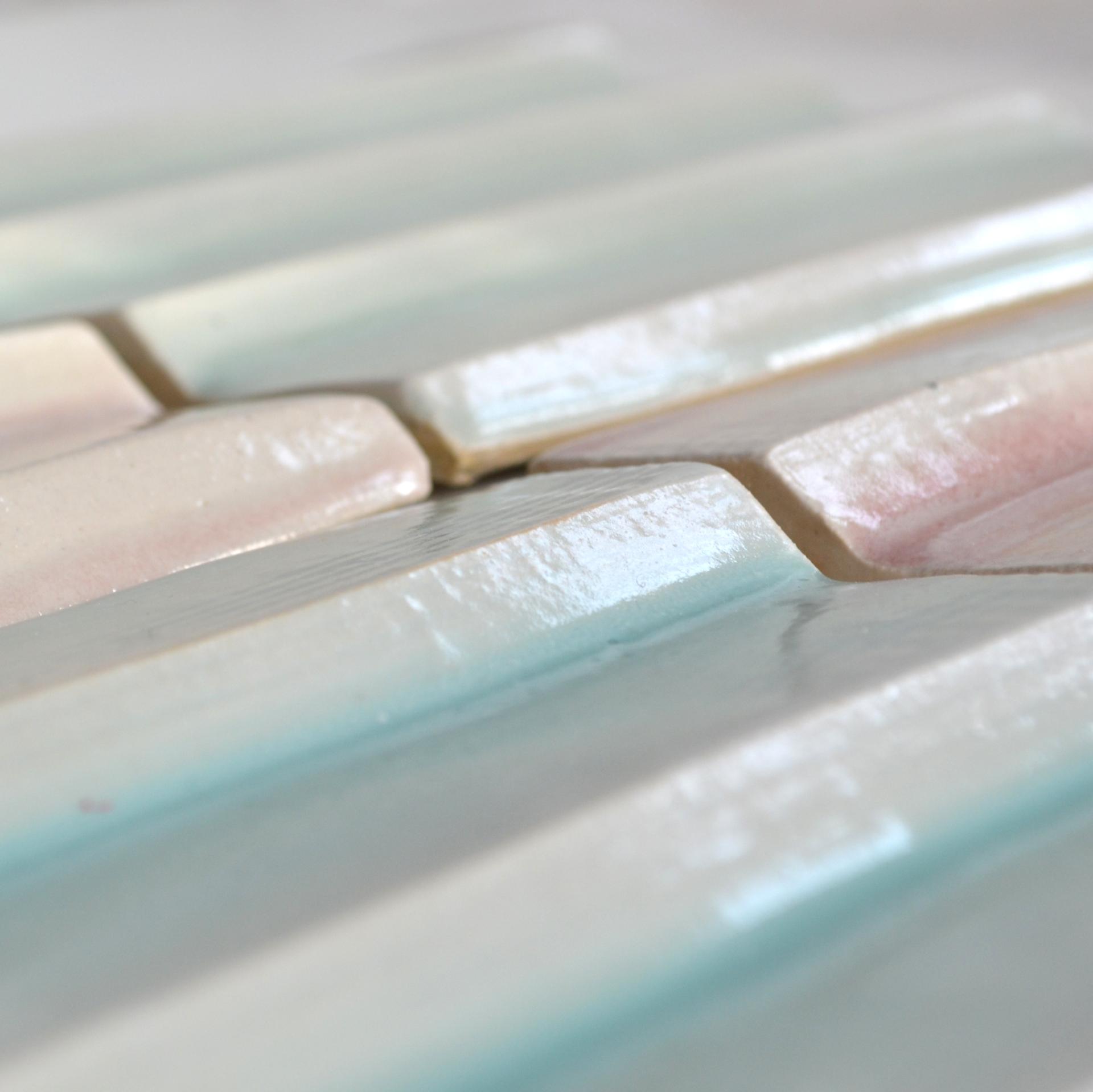 Textured ceramic tiles in soft pastel hues, showcasing craftsmanship and design in contemporary architecture exhibition.