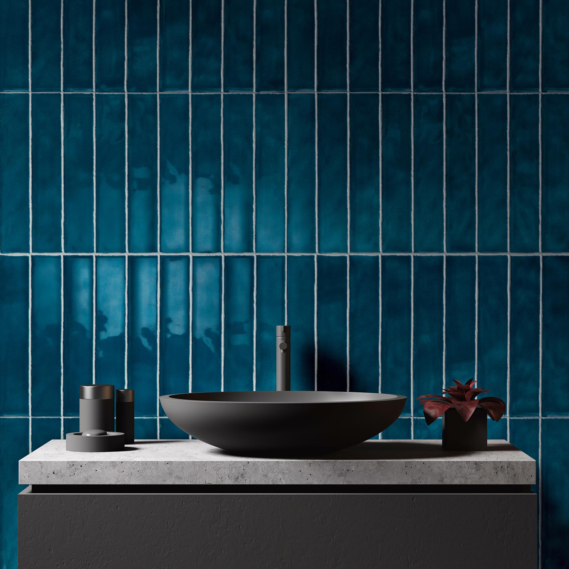 Stylish bathroom design featuring a dark bowl sink, concrete countertop, and vibrant teal tile wall.