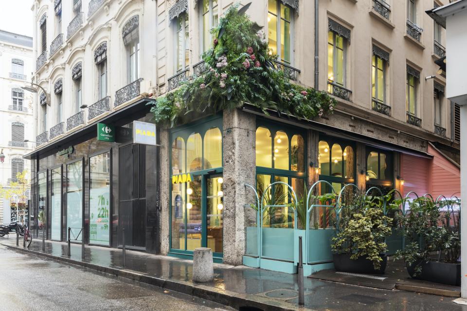Piada's second shop in Lyon featuring a vibrant candy color palette and lush greenery at the entrance.