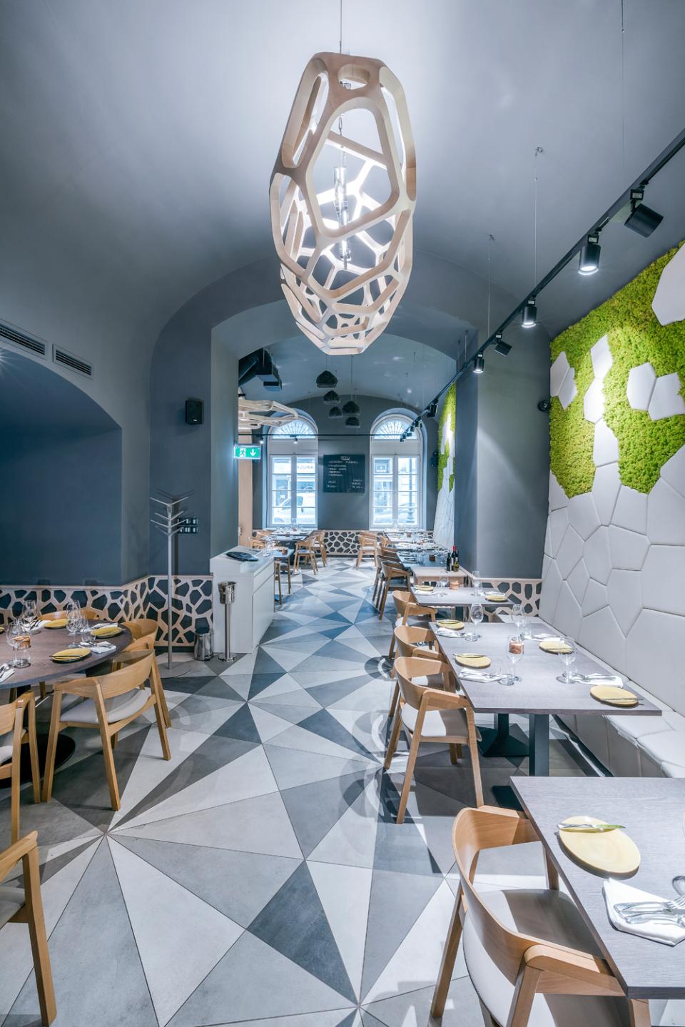 Interior view of Textúra restaurant showcasing parametric design, unique lighting, and geometric patterned flooring.