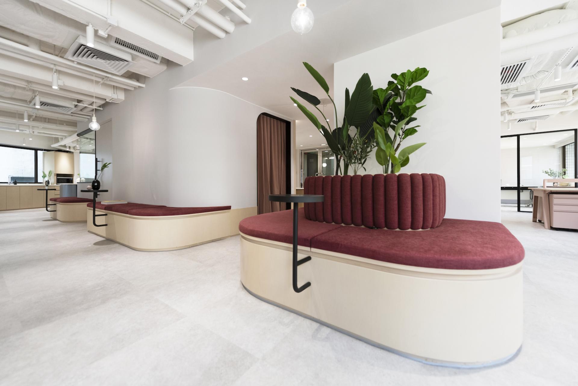 Modern office space featuring curved seating with a planter, designed for Charterhouse's Asia office collaboration by Bean Buro.