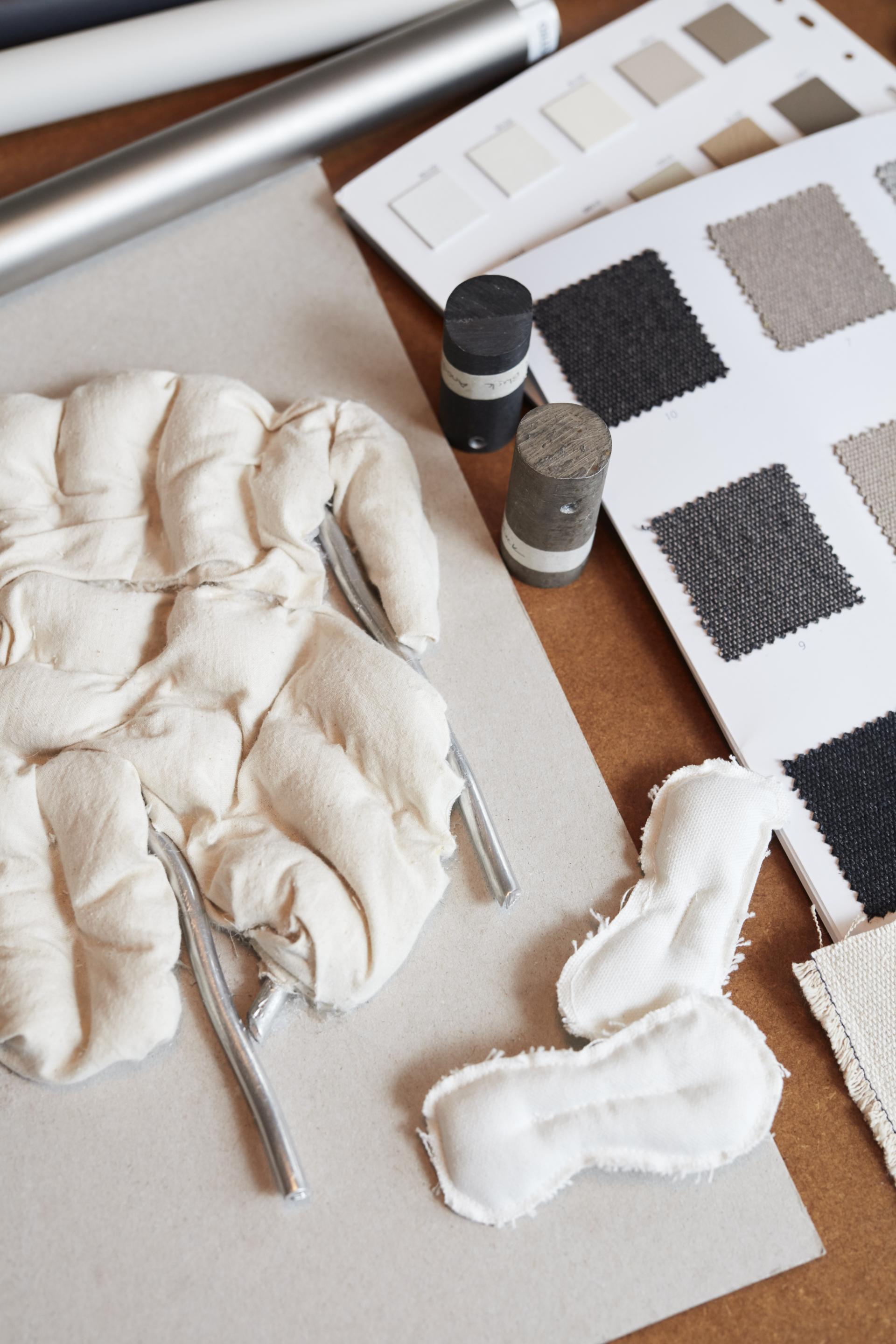 Textiles and materials for Hem's Puffy Lounge Chair showcase in a design studio setting.