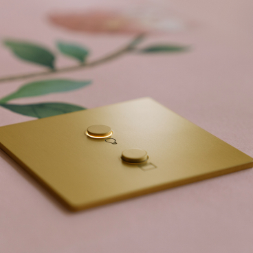 Gold Lutron Alisse wall control positioned on floral background, part of HomeWorks lighting and shading solutions.