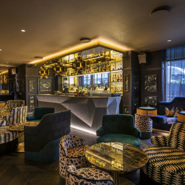Luxurious bar interior at The Colony Club featuring stylish seating and a glamorous atmosphere with elegant decor.