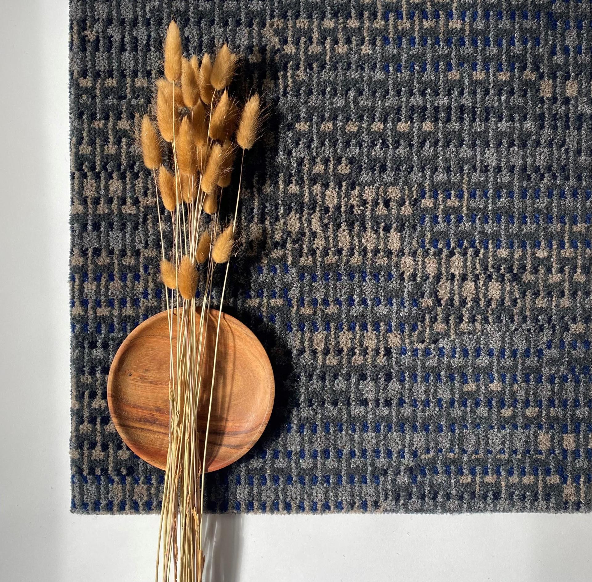 Creative Macramé Collection carpet featuring intricate patterns, accented by dried stems and a wooden plate.