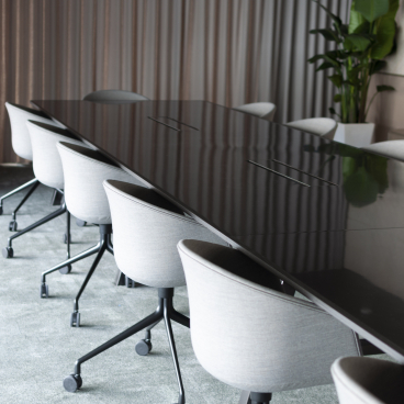 Modern conference room designed by Bean Buro for Warner Music Hong Kong, featuring a sleek black table and stylish chairs.
