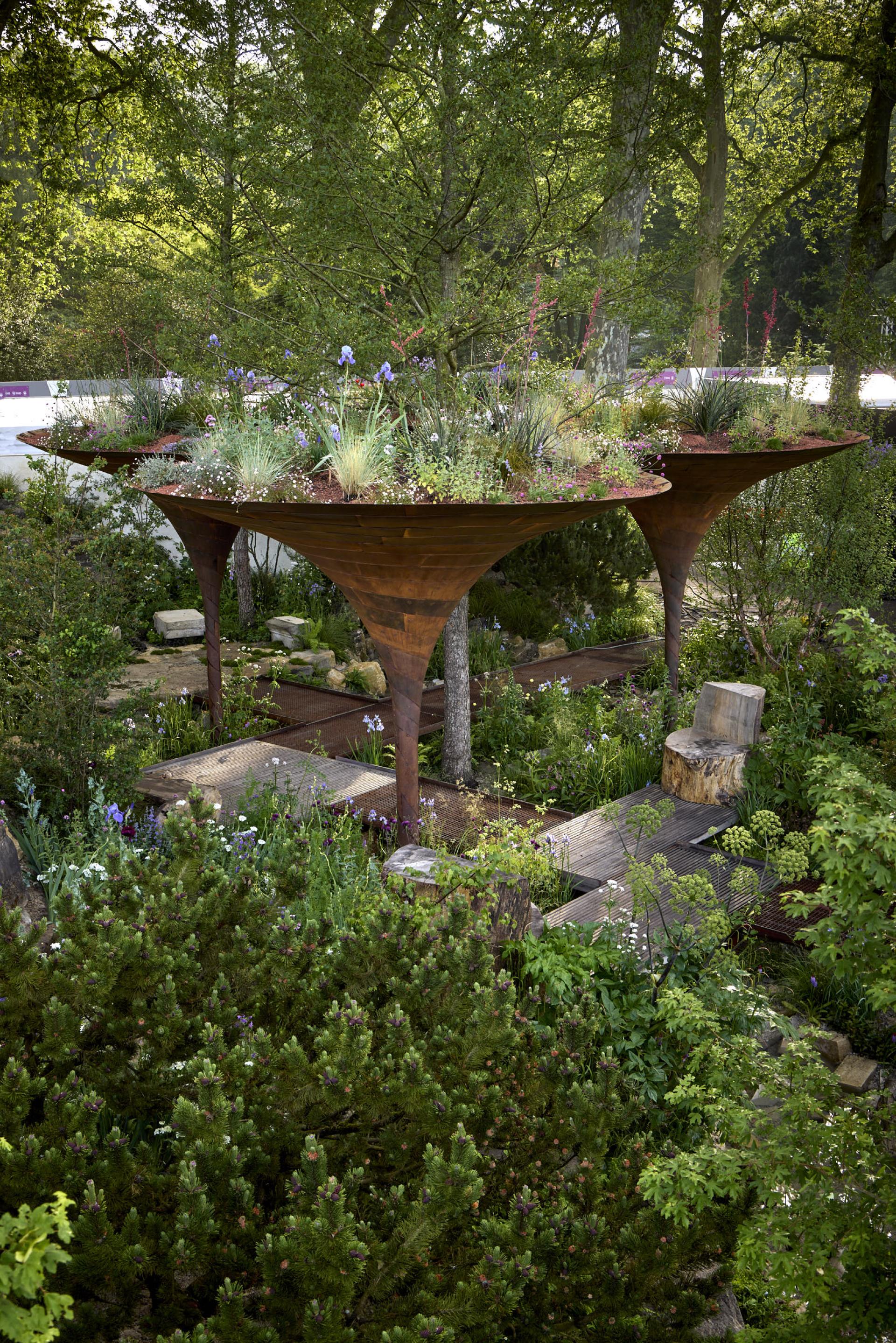 Contemporary garden design featuring raised planters, diverse plants, and sustainable materials, showcased at RHS Chelsea Flower Show.