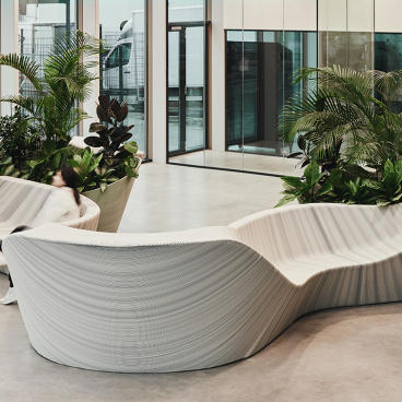 Multifunctional entrance furniture by The New Raw, featuring sculptural design and integrated greenery in a modern space.