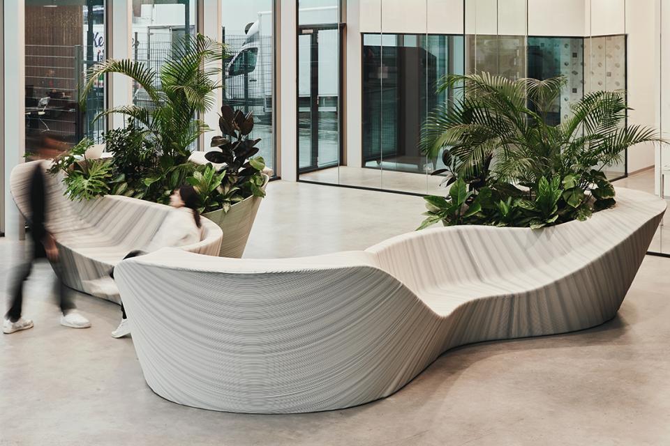 Multifunctional entrance furniture by The New Raw, featuring sculptural design and integrated greenery in a modern space.