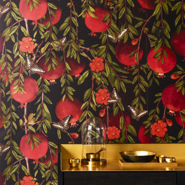 Dramatic floral wallpaper featuring red pomegranates, butterflies, and vibrant blooms, complementing a chic black and gold décor.