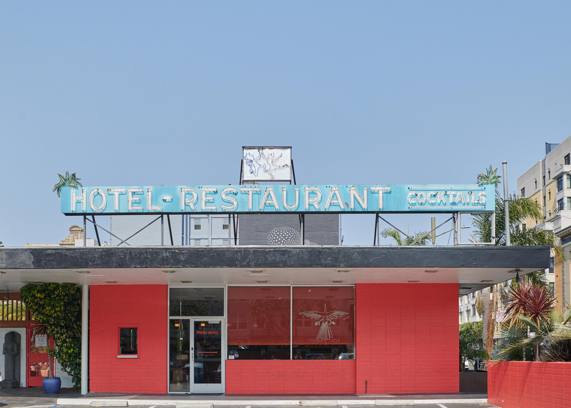 Colorful facade of the Phoenix Hotel in San Francisco's Tenderloin, featuring a vintage-style sign for hotel and restaurant.
