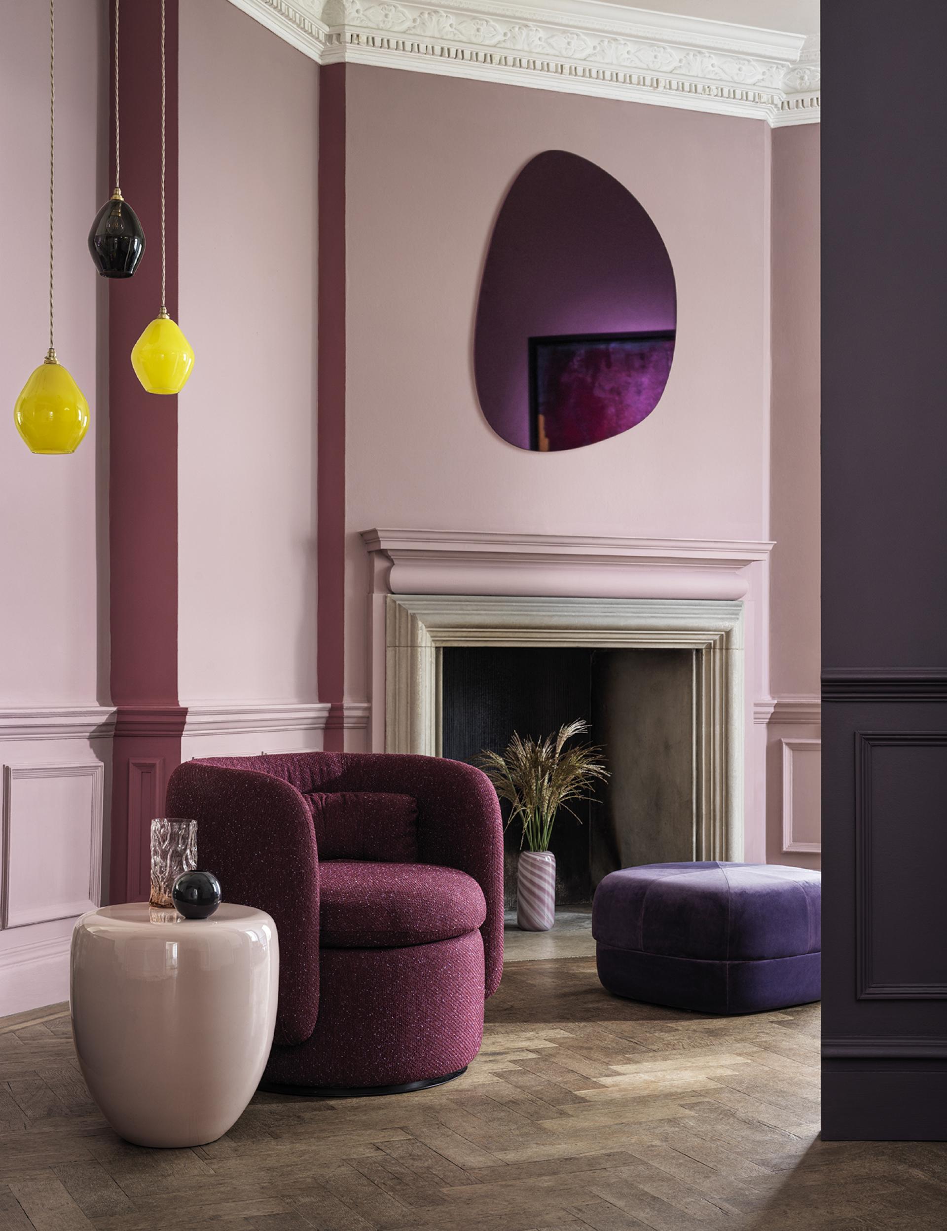 Trendy interior featuring purple and pink walls, modern furniture, and decorative pendant lights reflecting SS22 color trends.
