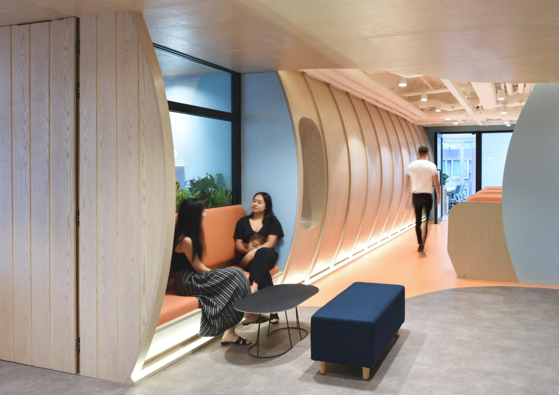 Modern office space designed for travel technology, featuring comfortable seating, vibrant colors, and stylish architecture.