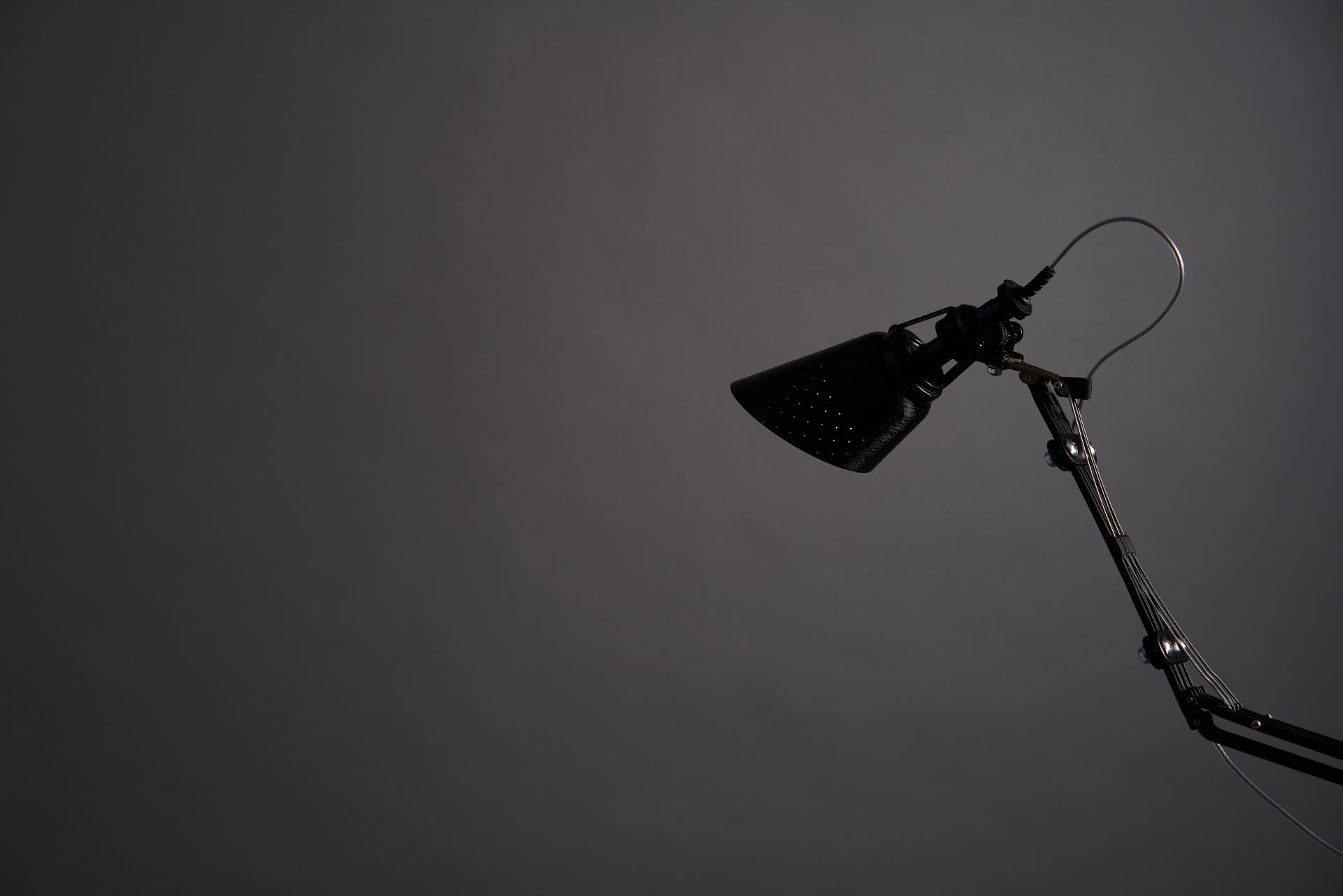 Upcycled lamp made from a discarded umbrella, showcasing a sleek black design against a dark background.