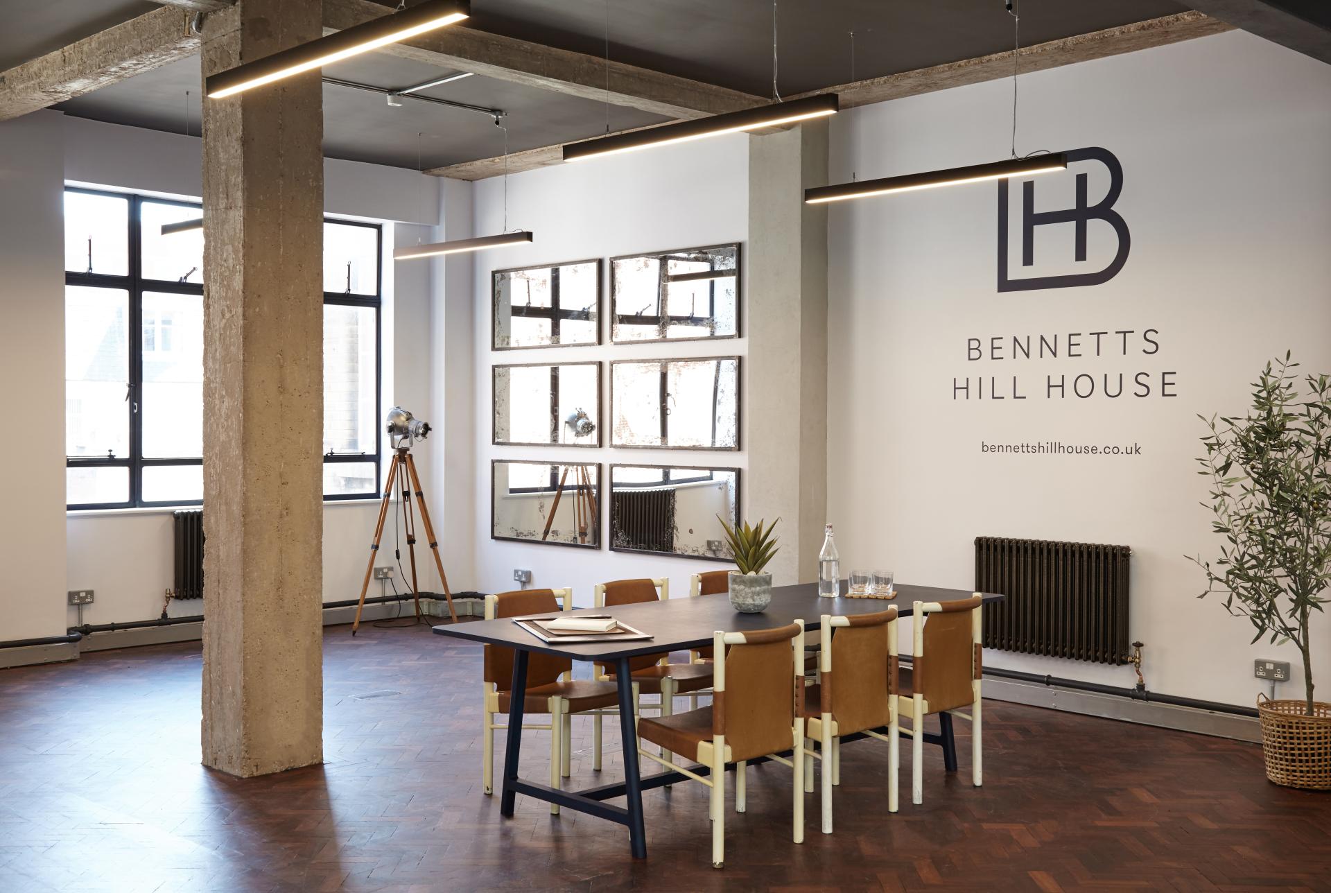 Chic, loft-style office space featuring a modern meeting area with stylish furniture and industrial design elements.