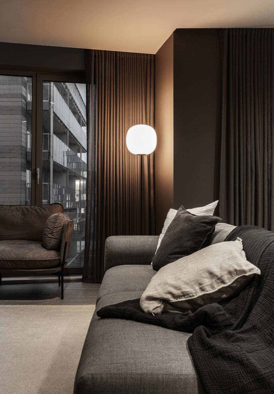 Modern living room in Manchester featuring cozy furniture, stylish lighting, and warm curtains, reflecting contemporary design.