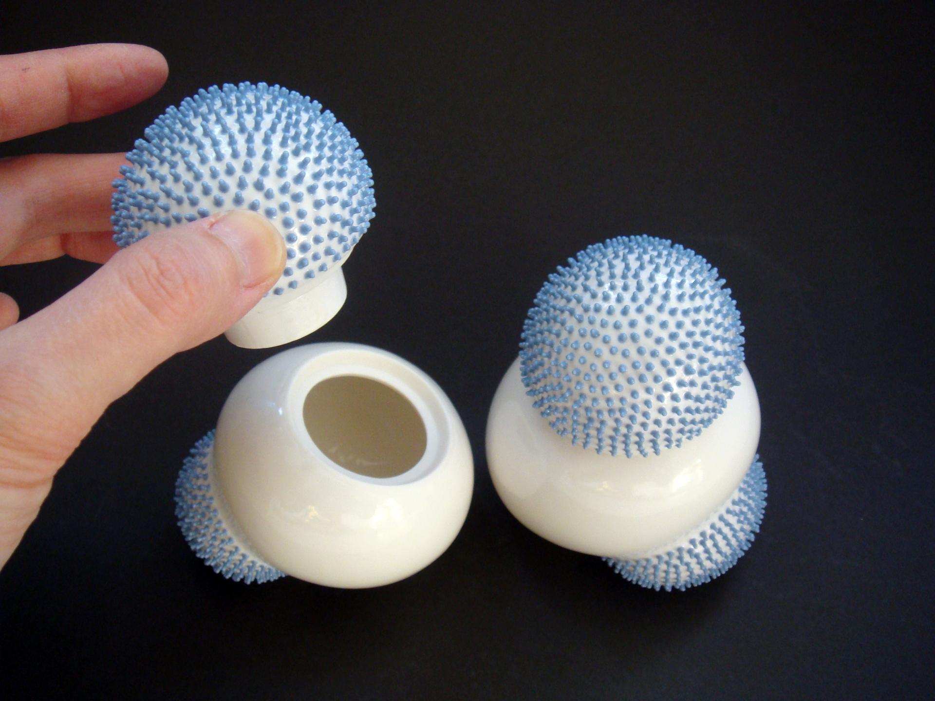 Contemporary ceramic sculptures with blue textured tops, displayed as part of curated art at the London Art Fair 2019.