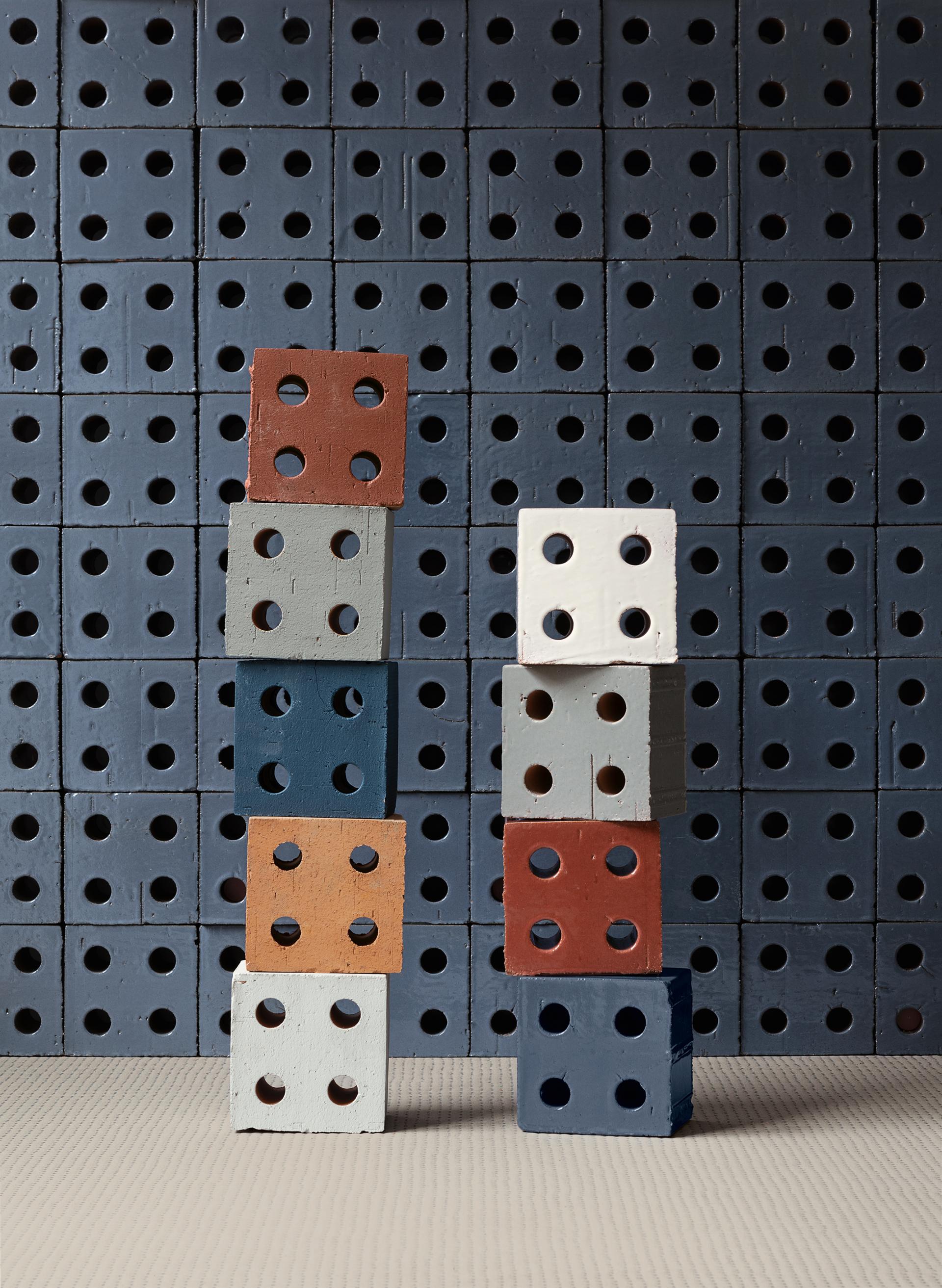 Colorful stacked ceramic blocks with circular holes, showcasing Mutina's design collaboration with Studio Bouroullec.