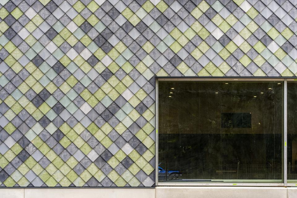 Sustainable building facade featuring eco-friendly materials in a geometric pattern, showcasing circular construction innovation by Pretty Plastic.