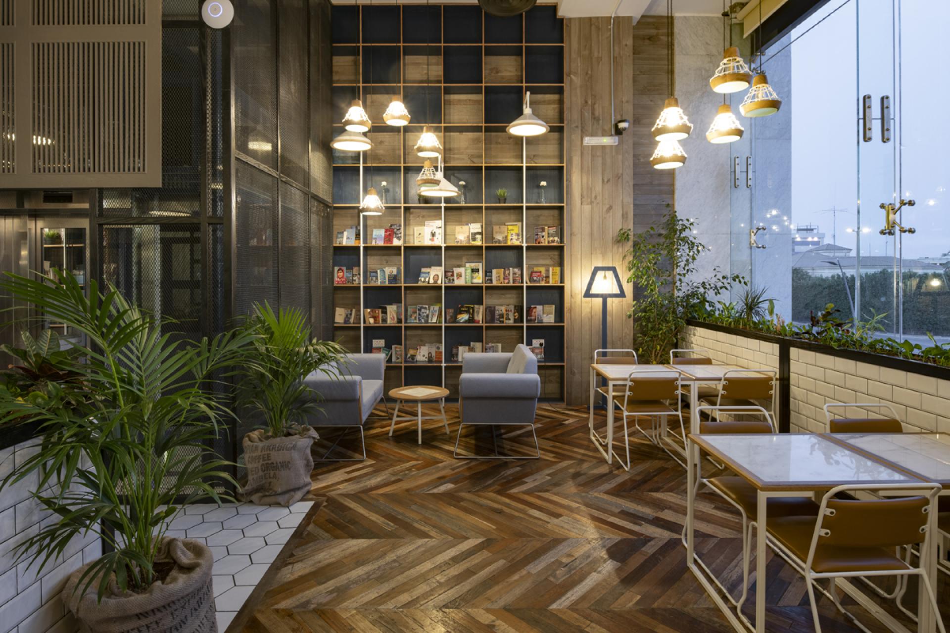 Cozy interior of Brew92 cafe featuring modern seating, plants, and a warm wooden floor design by Liqui Design.