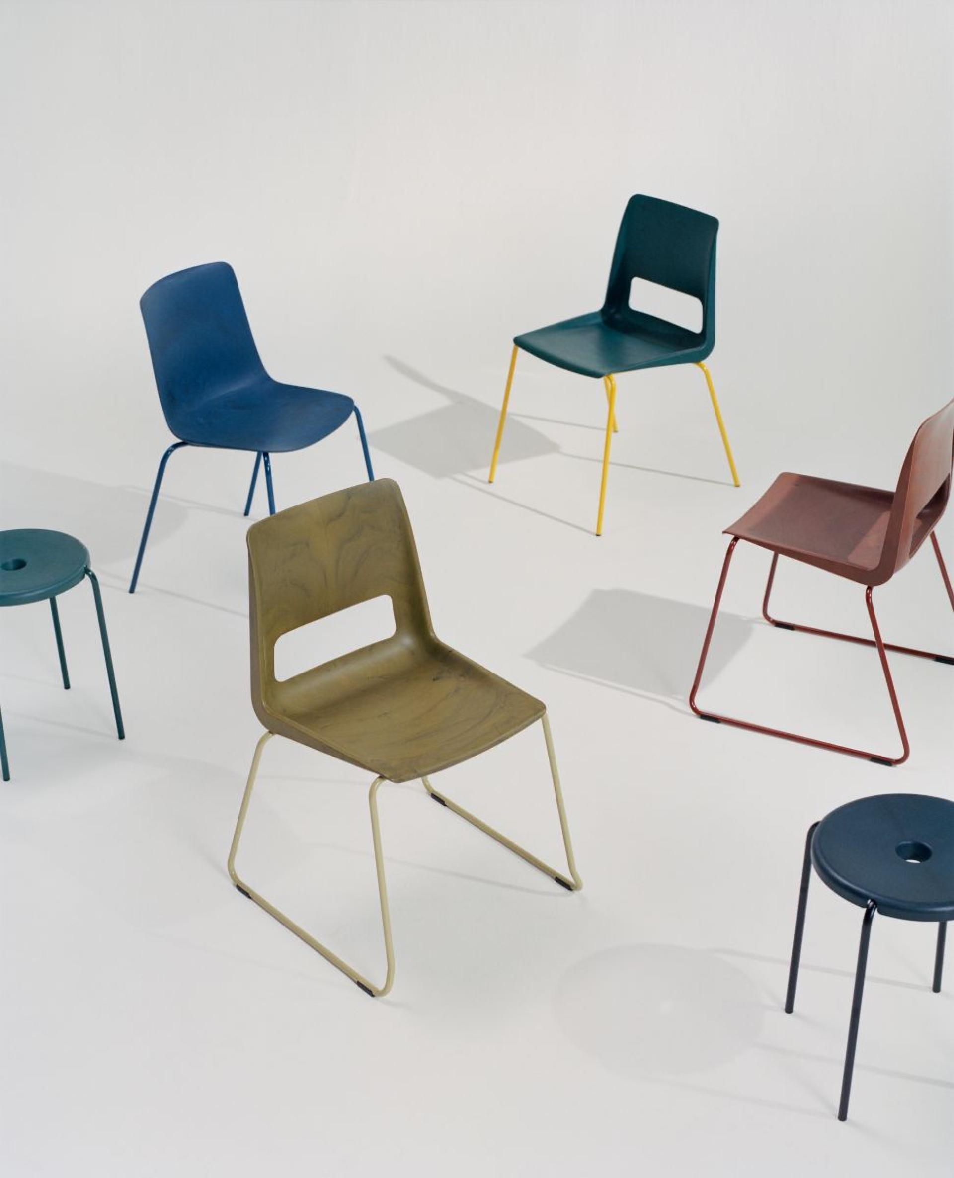 Colorful modern chairs arranged artistically on a white backdrop, showcasing Norway's innovative circular-design economy.