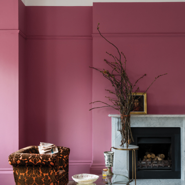 Cozy interior featuring Farrow & Ball's Sulking Room Pink, accented by vintage furniture and artistic decor elements.