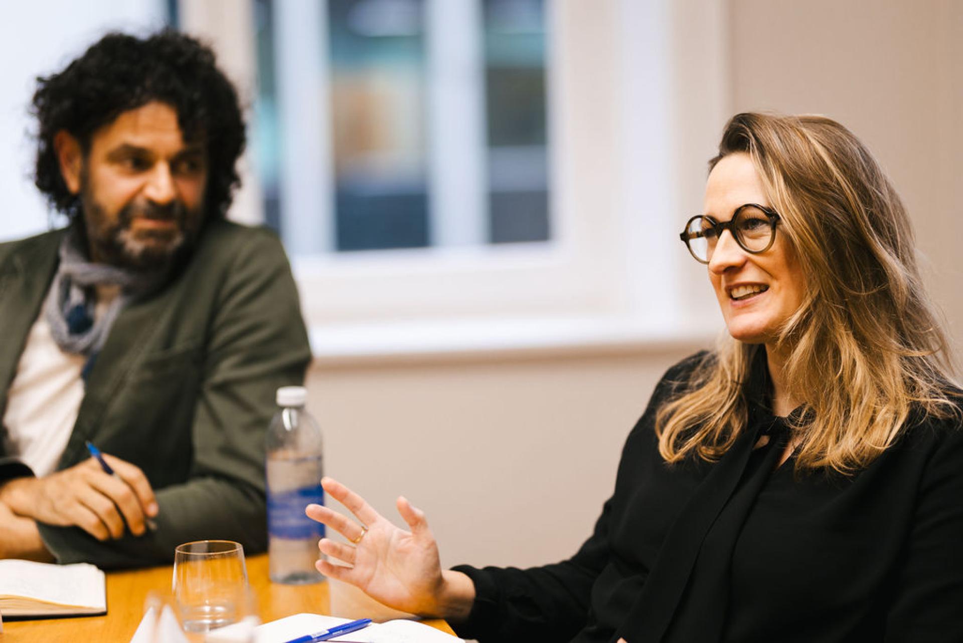 Discussion on Glasgow's property outlook featuring two participants engaged in a seminar conversation at a conference table.