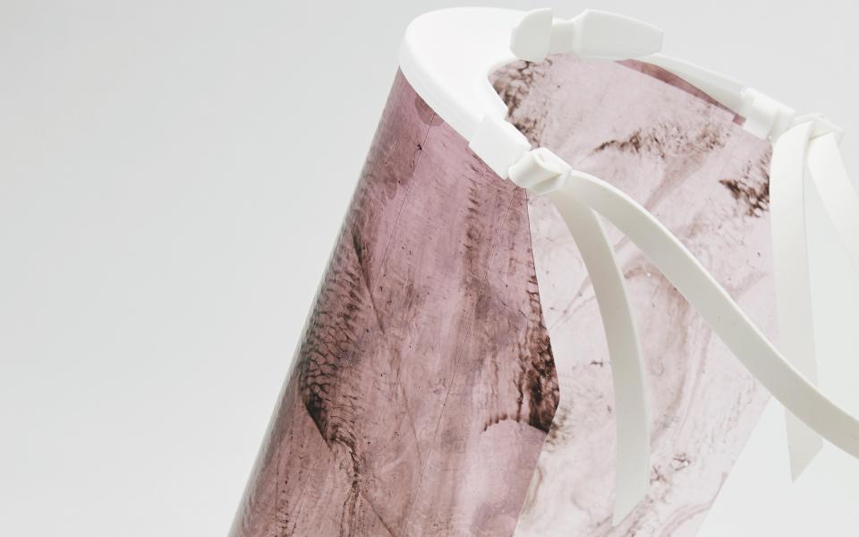 Biodegradable personal protective equipment designed by Alice Potts, showcasing a sleek, transparent design with a pink tint.