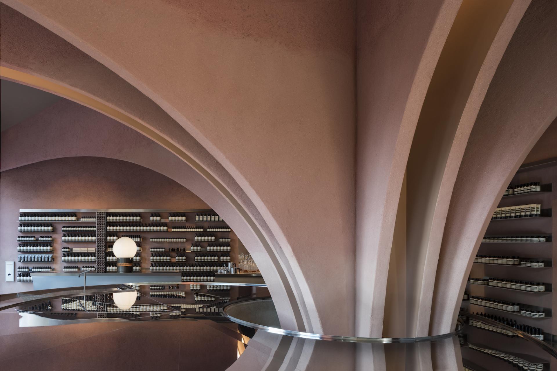 Elegant interior design of Maggie’s St Barts, showcasing unique arches and aromatic product displays, awarded at the Surface Design Awards 2019.