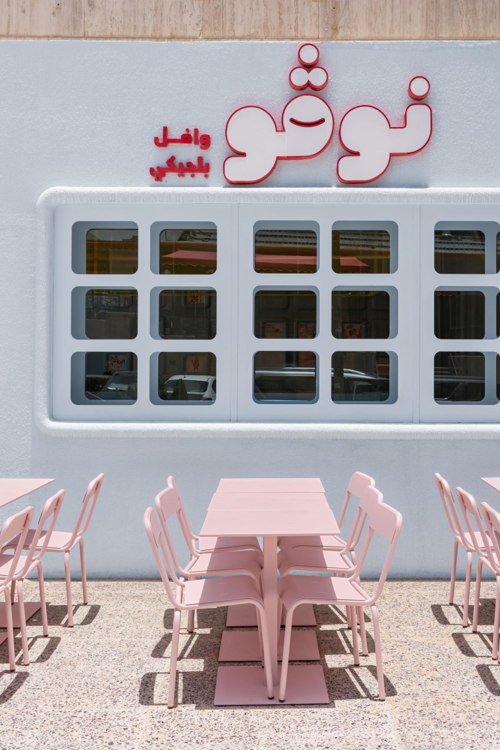 Novu Waffle's exterior features modern pink seating and a stylish white facade, highlighting Masquespacio's innovative design.
