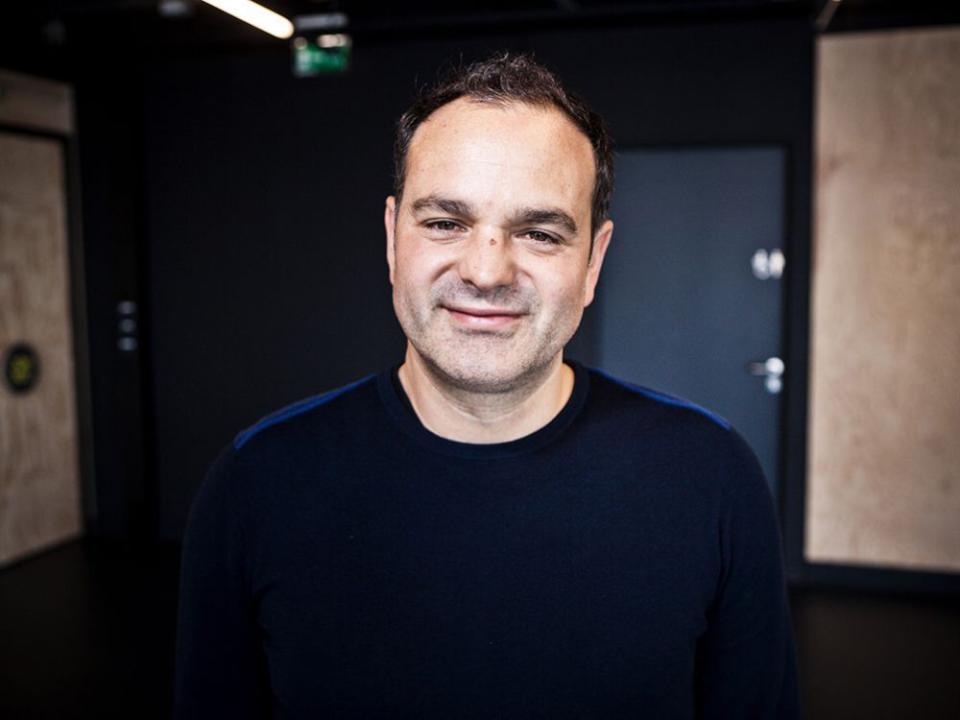 Lee Penson, CEO of PENSON, smiles confidently against a modern studio backdrop, reflecting his expertise in design and architecture.