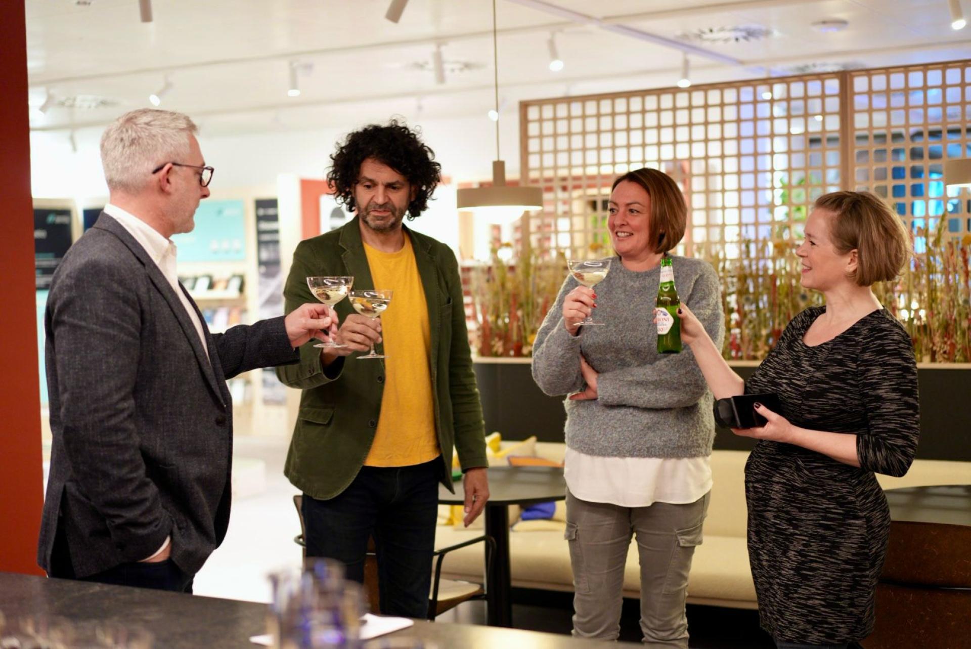 Colleagues toasting with drinks in a vibrant office setting, highlighting workplace camaraderie and social interactions.