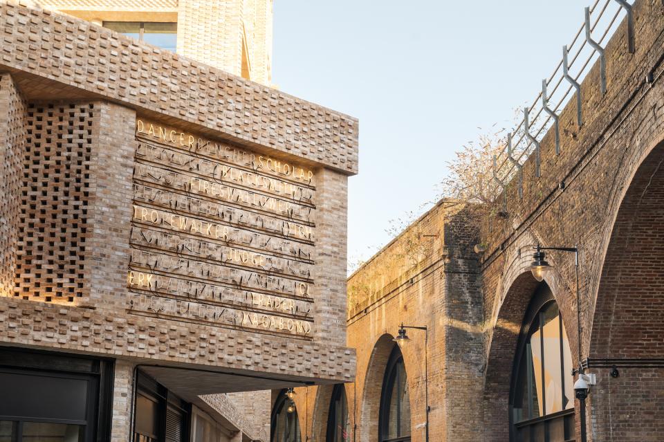 Modern architecture at Borough Yards features textured brick exterior with illuminated signage, highlighting a cultural destination in London.