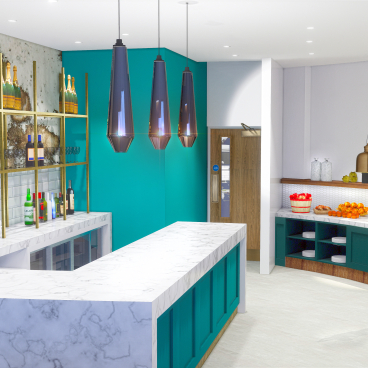 Stylish interior design of a modern bar featuring green accents, marble countertops, and elegant lighting in Manchester T2 lounge.