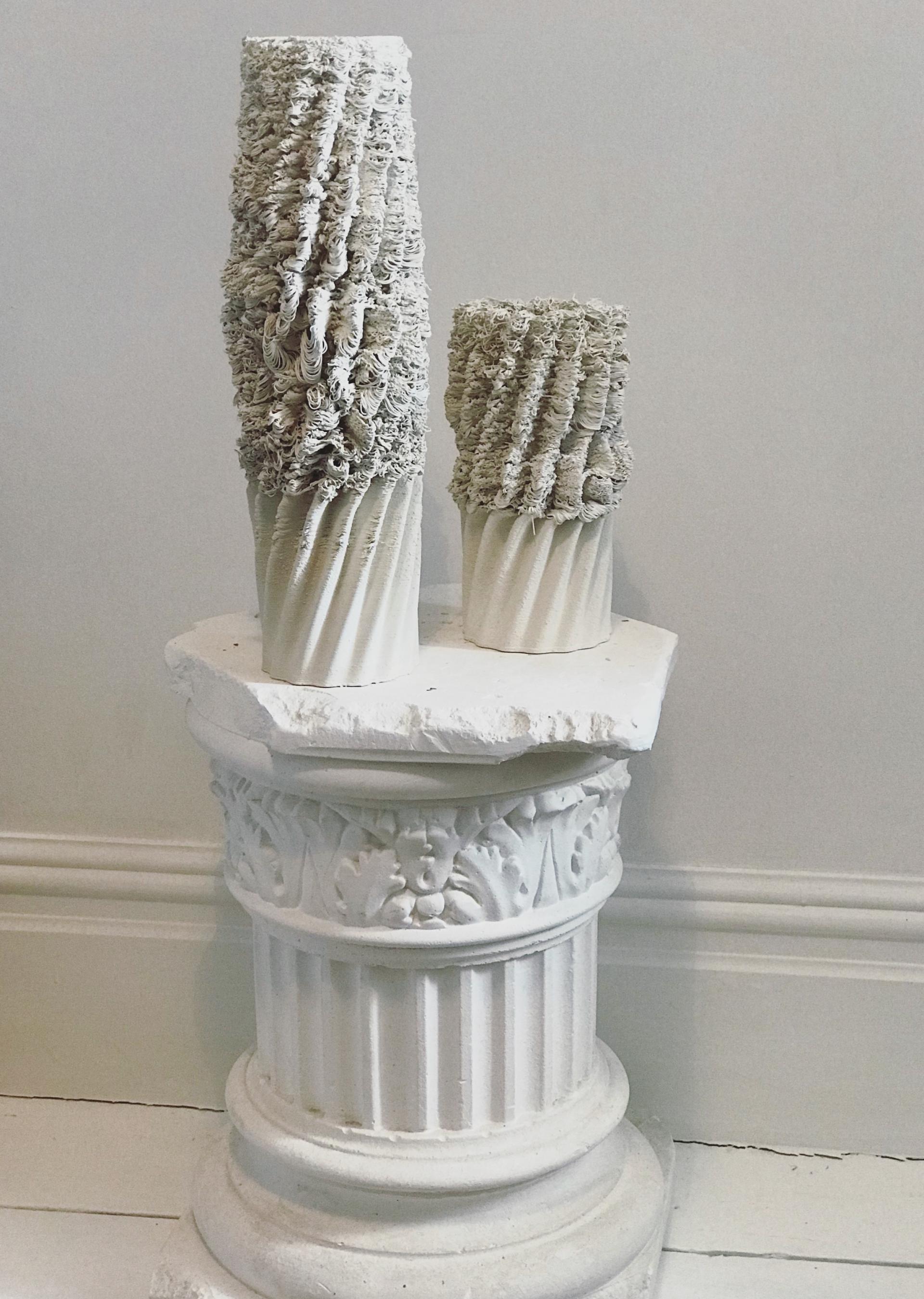 Textured white ceramic vases on an ornate pedestal, showcasing Ryan Barrett's innovative approach to ceramics and design.