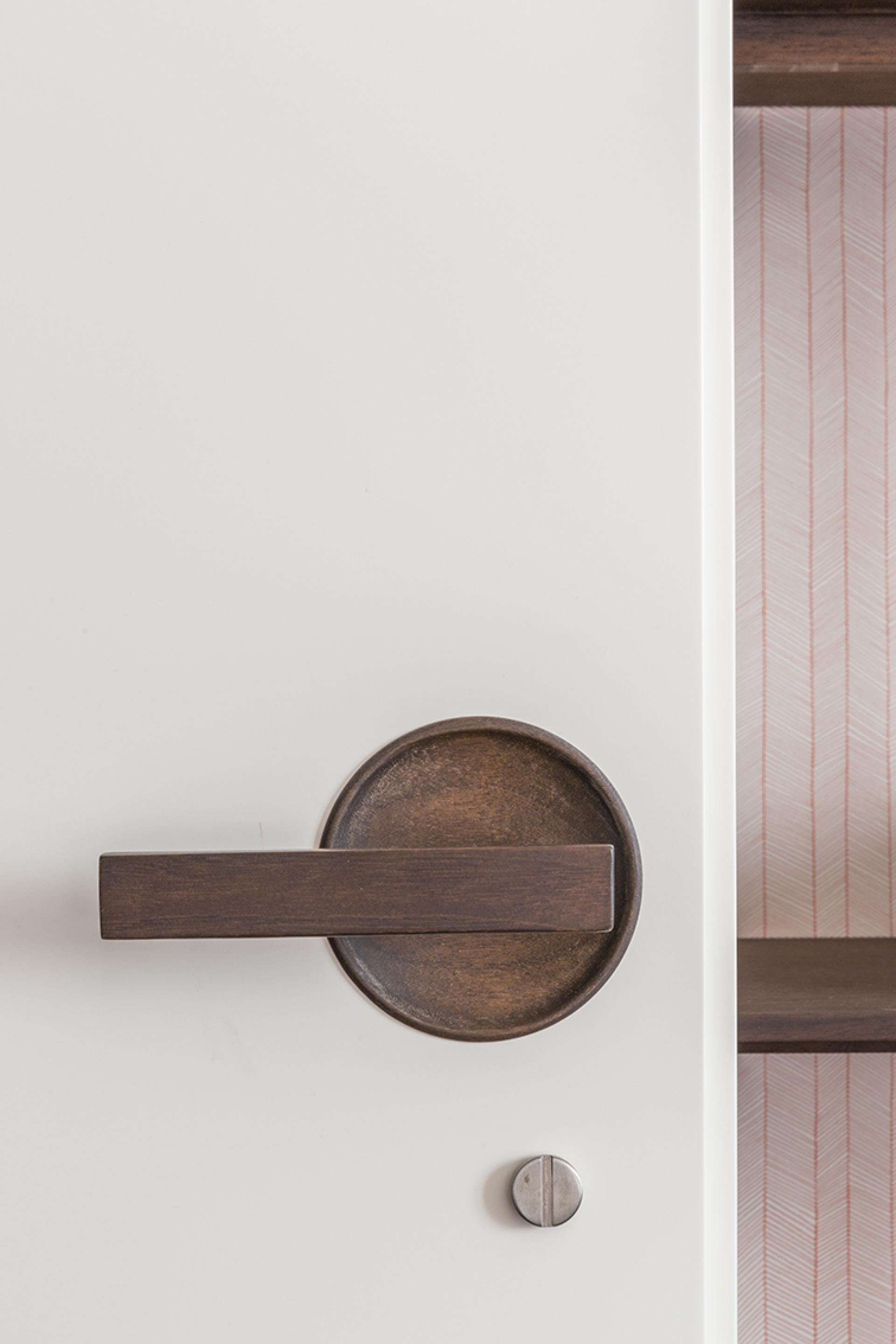 Modern door handle design on a minimalist white door, showcasing artistic craftsmanship in the artist's loft above the Colosseum.