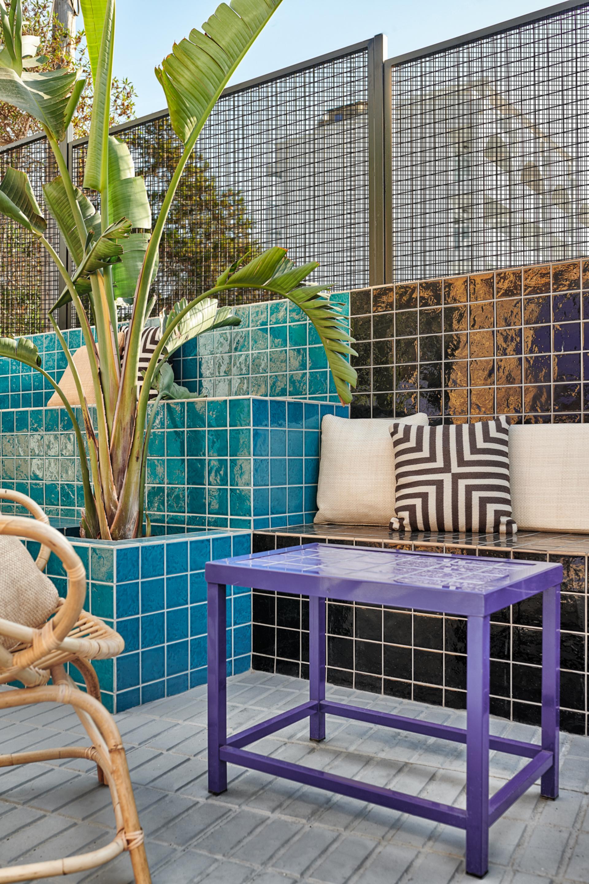 Vibrant seating area at Bar TORÖ in Ibiza, featuring Mediterranean-inspired tiles and lush greenery.