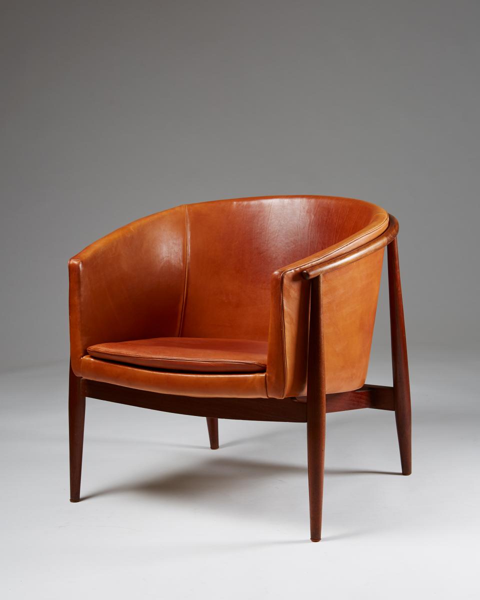 Classic mid-century modern leather chair showcasing rich tones and elegant design, perfect for furniture enthusiasts and collectors.