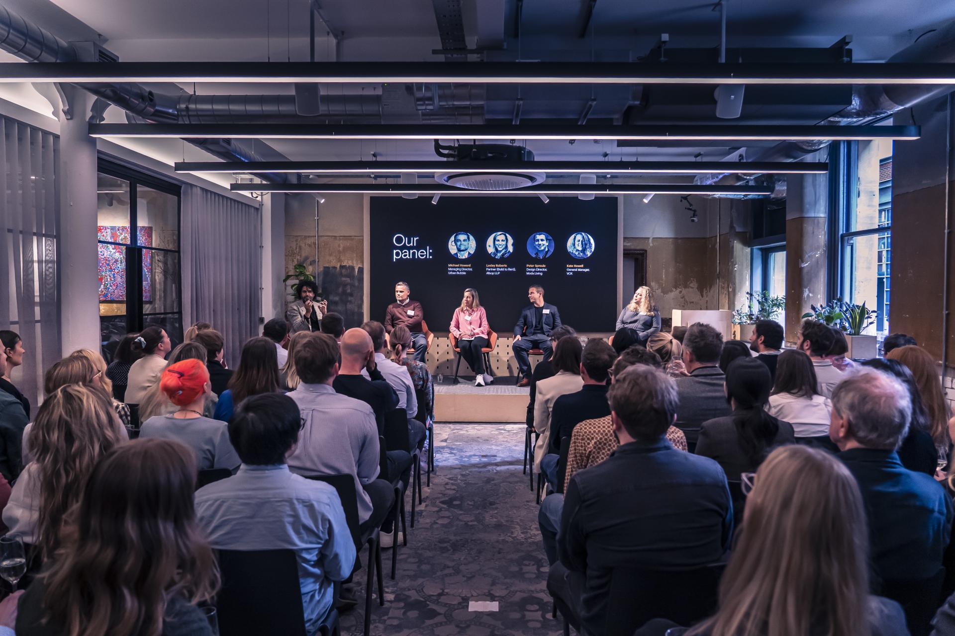 Panel discussion on the future of residential design featuring expert speakers and an engaged audience in an urban venue.