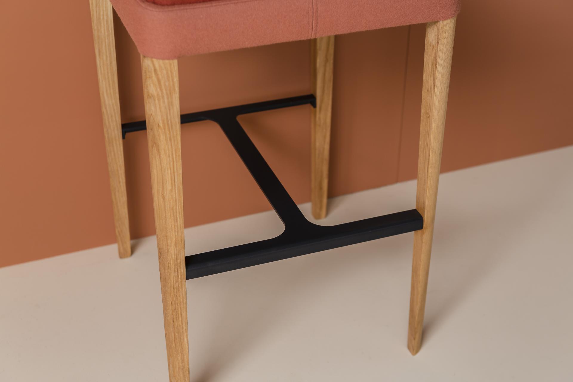 Stylish Kyoto collection bar stool featuring a sleek design with wooden legs and a cushioned seat in warm tones.