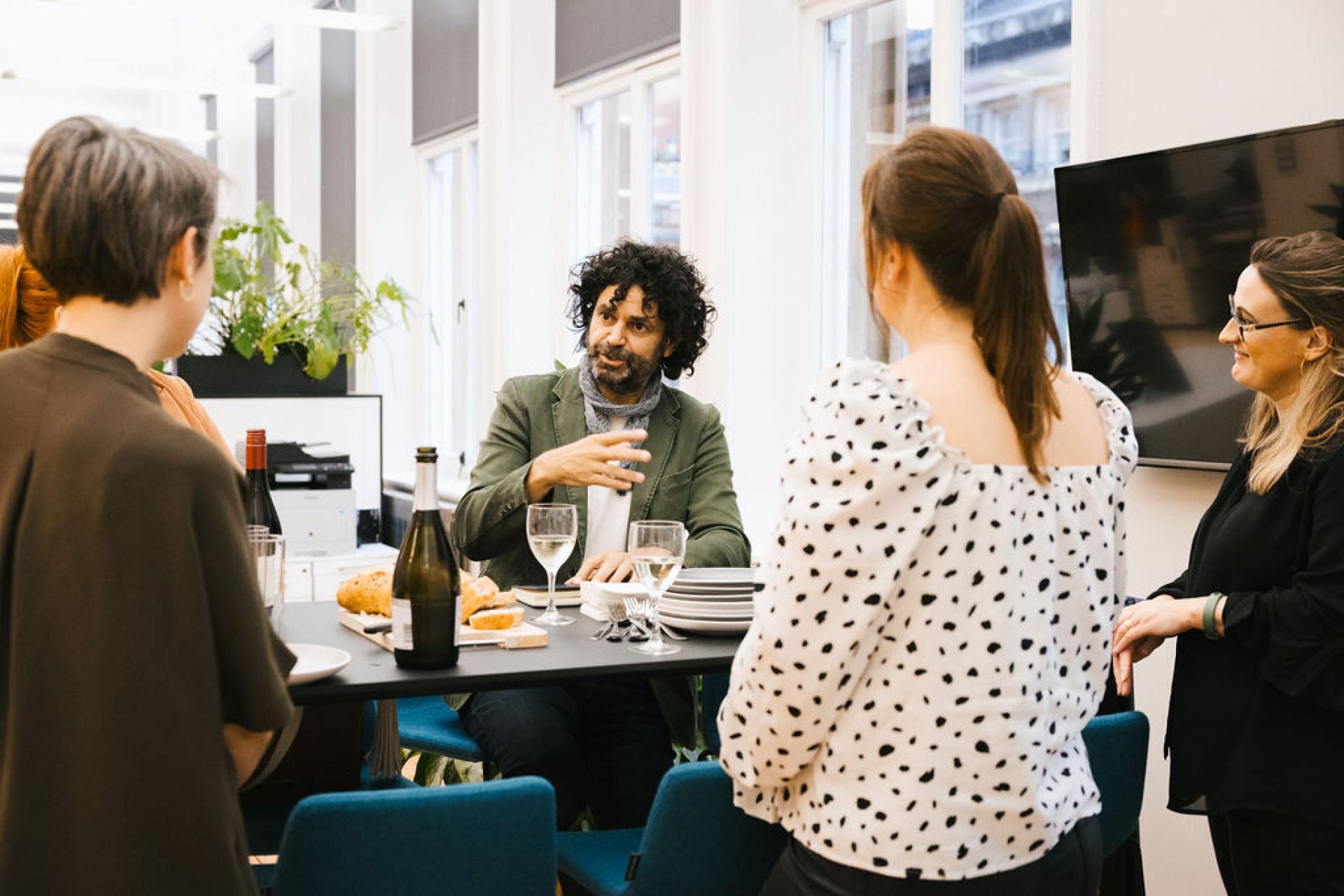 Discussion among participants at Glasgow real estate seminar, with food and drinks on the table.