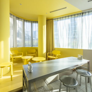 Bright yellow-themed modern interior featuring stylish chairs and a sleek table, perfect for autumn color inspiration.