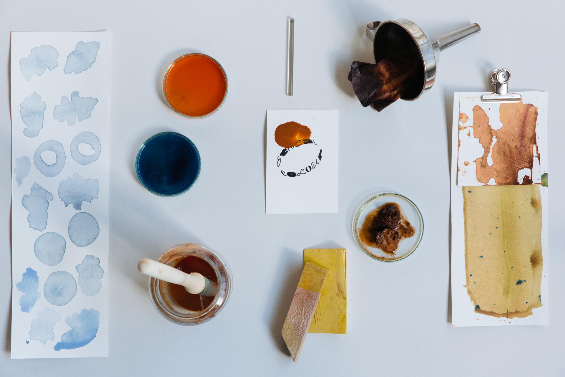 Colorful paint samples, watercolor swatches, and design tools on a table, showcasing materials for sustainable design in circularity.
