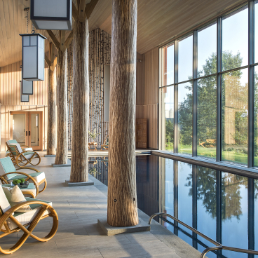 Modern pool house interior featuring sleek design, large windows with Catskills views, and stylish seating for relaxation.