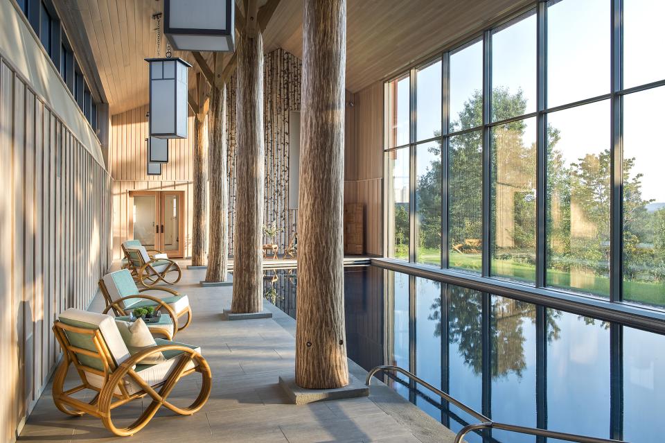 Modern pool house interior featuring sleek design, large windows with Catskills views, and stylish seating for relaxation.