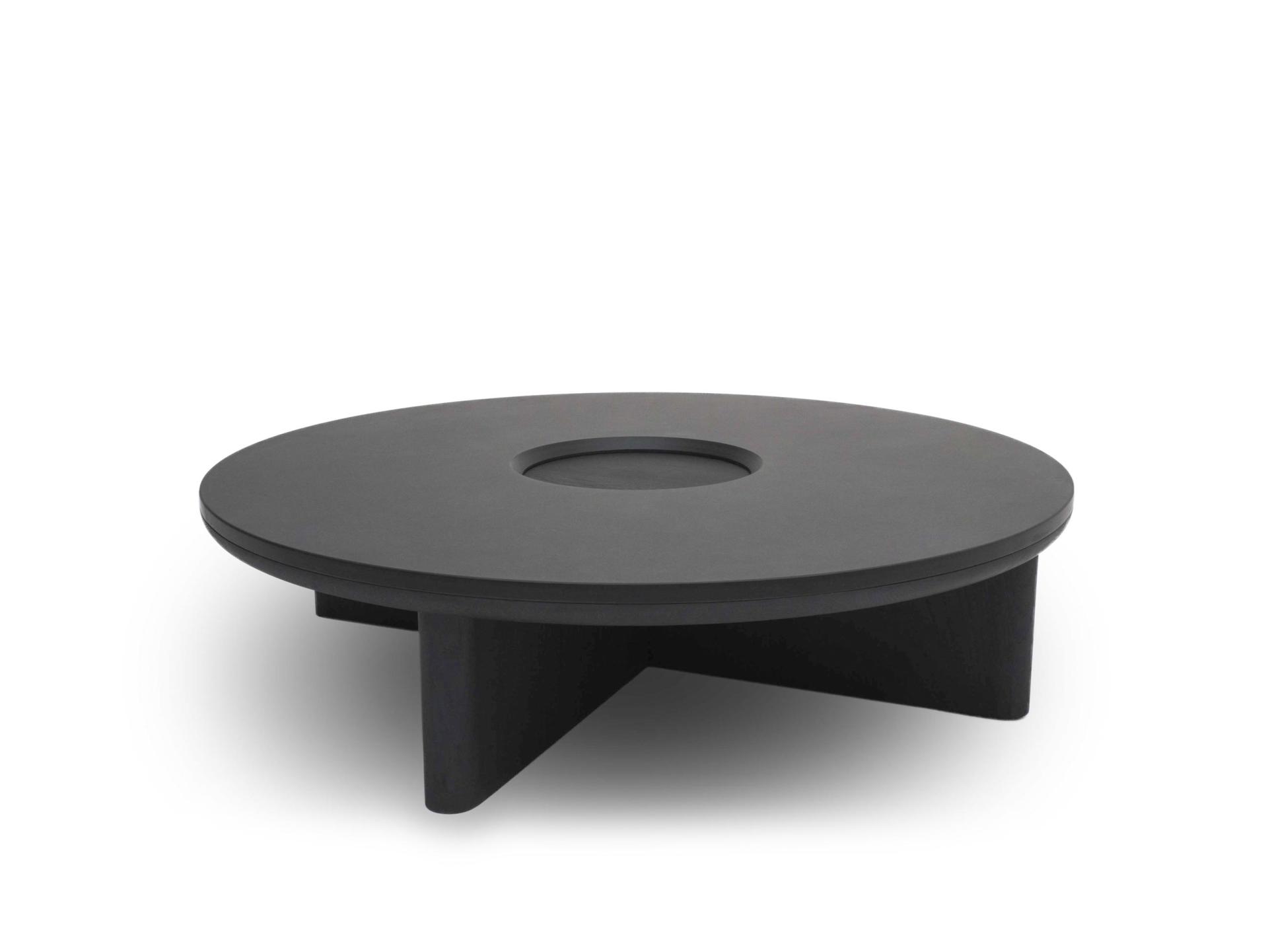 Sleek black coffee table with a round design and a central cut-out, highlighting bold geometric furniture aesthetics.