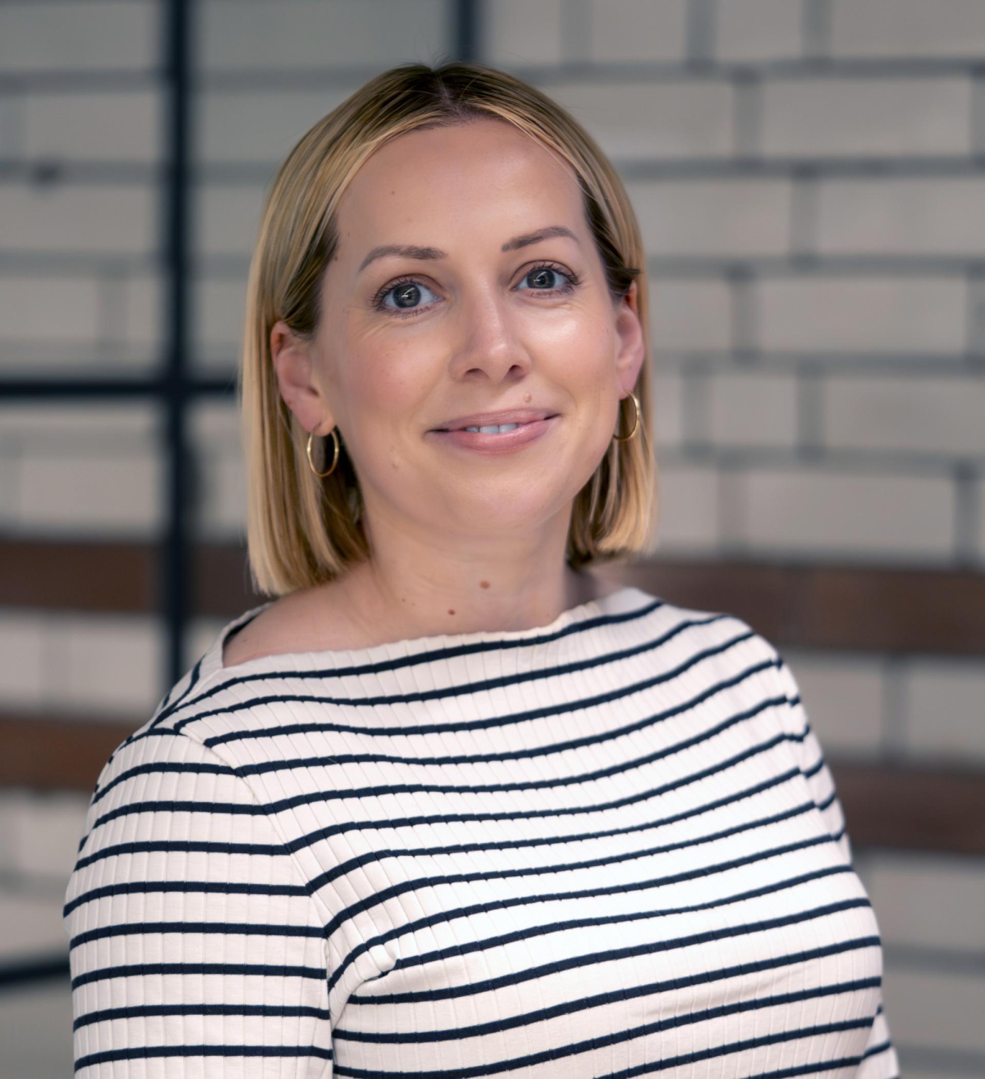 Professional interview subject smiling, wearing a striped top, representing diverse voices in 2024's most-read discussions.